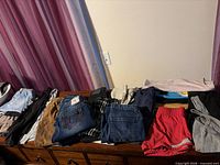 Overall view of folded children’s clothing on dresser