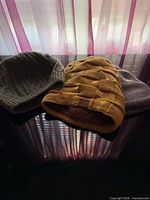 Three beanies displayed together showing colors and styles