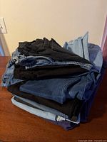 Stack of six folded pants showing color variety
