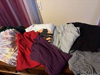 All eight garments spread on surface showing colors and styles