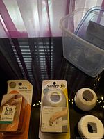 Packaged knob covers, latches, and storage box on table