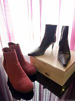 Both pairs of boots side by side on tabletop, showing styles and colors