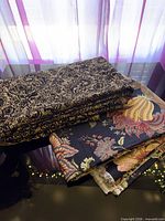 Stacked abstract black/tan fabric and separate floral fabric showing both pieces