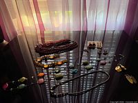 Full view of all necklaces and earrings on black surface