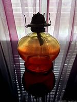 Side view of lamp showing amber to red color gradient and brass burner