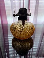 Front view showing amber glass reservoir pattern and metal burner