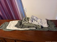 Stack of five clothing items folded on dresser