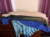 Stack of five assorted dresses on dresser