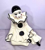 Front view of seated ceramic Pierrot clown statue