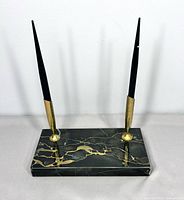 Full view of two pens on marble base