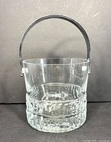 Front view of clear crystal ice bucket with chrome handle