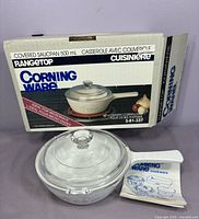 Saucepan with lid inside original box with booklet visible