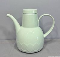 front view of white porcelain coffee pot with lid