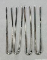 Five silver-plated U-shaped hair pins side by side