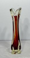 Full front view of red and clear swung glass vase