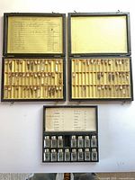 Overall view of open case showing two trays of vials and one tray of metal containers
