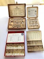 Overview of four open boxes with vials of watch parts