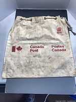 Full view of front of Canada Post canvas mail bag showing logos and overall wear