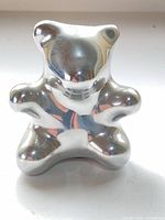 Front view of polished metal bear sculpture
