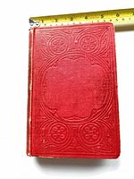 Front cover showing red embossed cloth binding with ruler for scale
