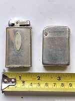 Front view of both pocket lighters alongside tape measure showing size
