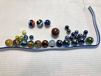 All marbles lined in a row showing variety of colors, patterns and sizes