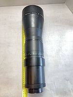 Full view of lens beside tape measure showing length