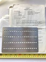 Cleaning plate resting on instruction sheet, both items visible