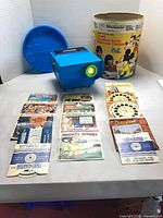 Overall lot with projector illuminated, canister, and reel packets