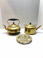 Overall lot showing both brass kettles and Fu trivet