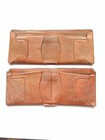 Both brown and tan leather check wallets fully opened, showing interior layout and wear