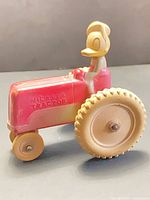 Full view of rubber toy tractor showing Donald Duck driver and wheels