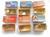 Nine matchboxes filled with watch parts and dials