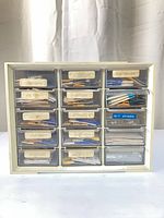 Full view of 15-drawer plastic organizer filled with watch part packets