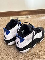 Rear/side view of both shoes showing colorway, Jumpman logo, heel pull tab and condition