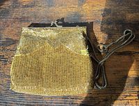 Front view showing gold bead exterior, kiss lock frame and chain strap