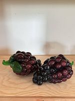 Both purple art glass grape clusters side by side showcasing size and form