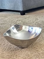Angled view of polished metal bowl showing shape and finish