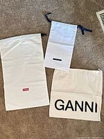 All three dust bags laid out showing brand logos and relative sizes