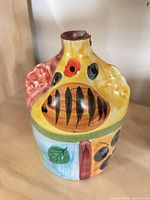Front view of small ceramic vase showing floral painting