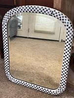 Front view of arched rectangular mirror with checkerboard frame