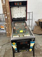 Front view showing cabinet, playfield under glass, coin door, missing backglass