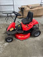 Left side view of red Craftsman 30 in riding mower showing seat, steering wheel, deck