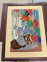 Full view of framed needlepoint clown artwork