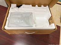 Monitor inside original foam packaging with power cable visible