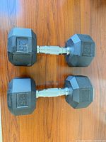 Pair of 25-lb rubber hex dumbbells on wooden surface