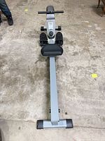 Full top view of rowing machine showing rail, seat, monitor, foot pedals