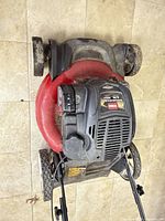 Top view of Toro mower showing engine housing, red deck, front wheels