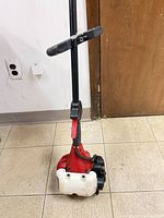 Engine housing, shaft handle, fuel tank visible