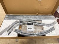 Box with aluminum frame pieces, styrofoam inserts, hardware and manual